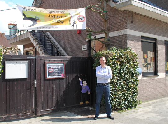 Wim Mommaers voor de schoolpoort van basisschool Opdorp
